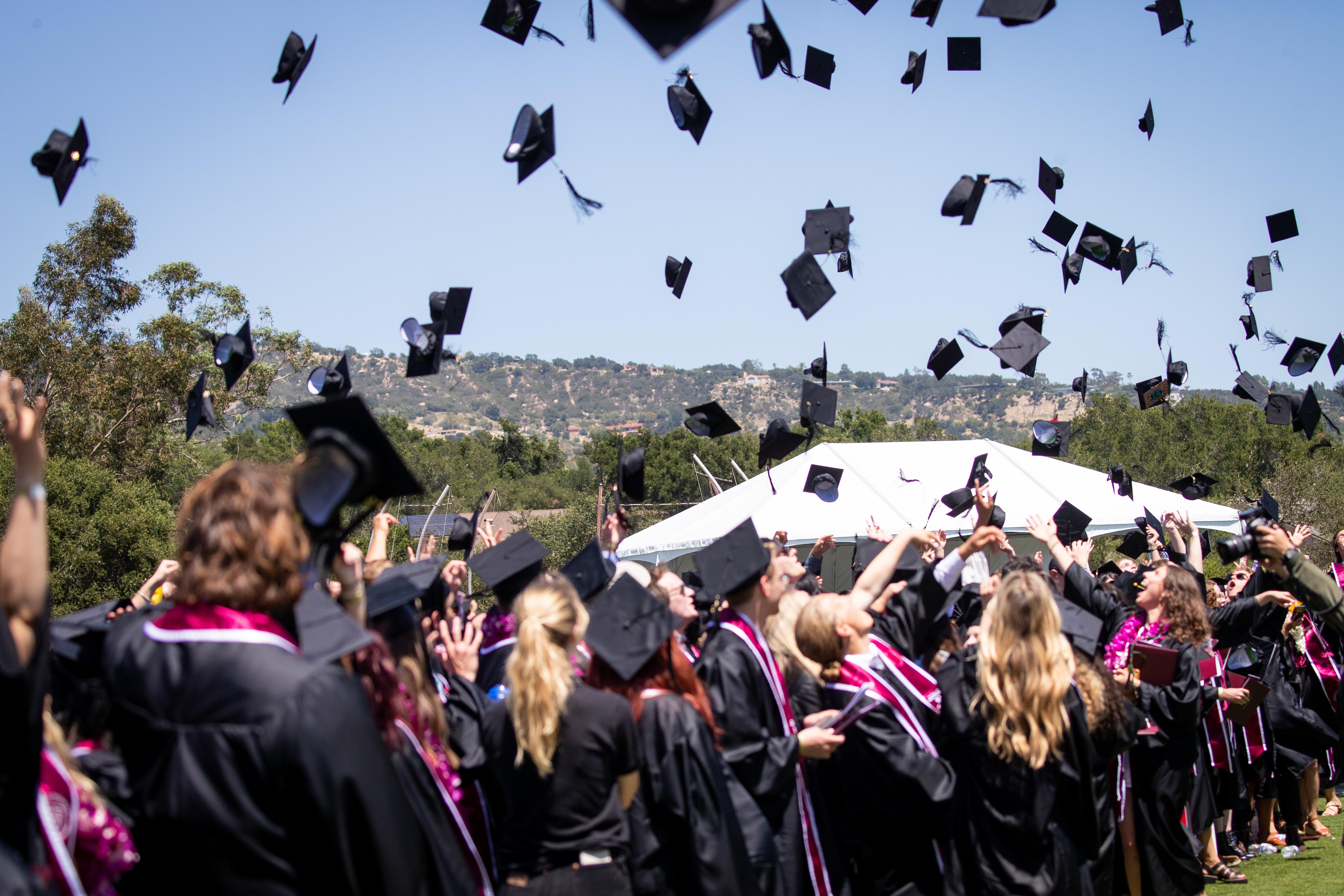 westmont graduates throwing caps in the air